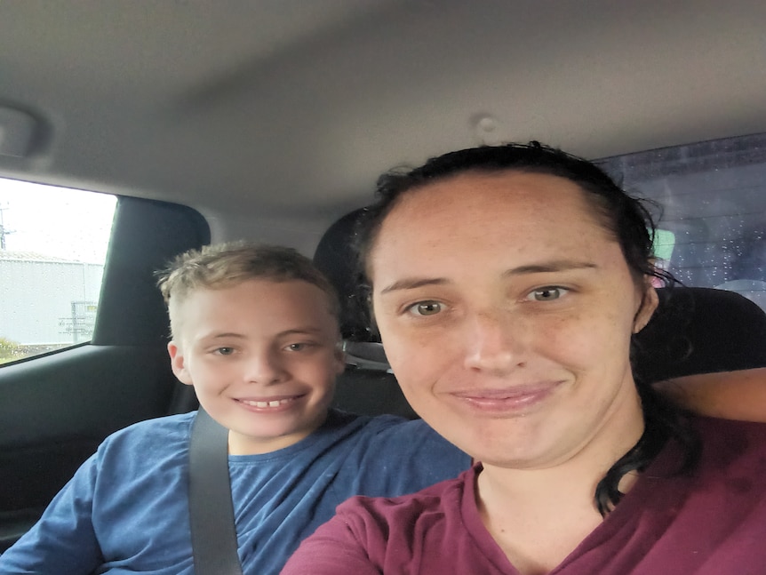 A woman and a teenage boy sitting in a car.