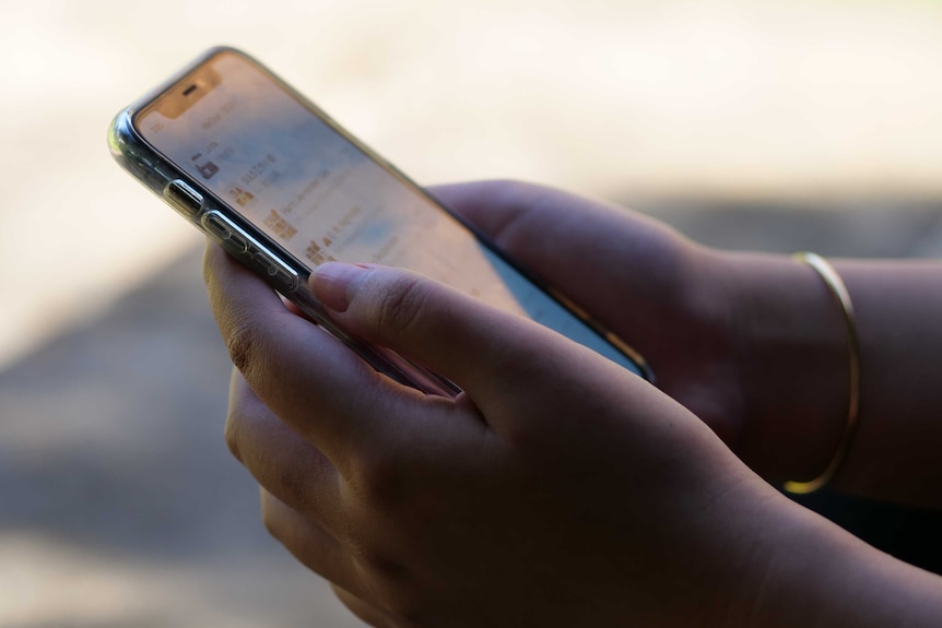 A pair of hands operating a smart phone.