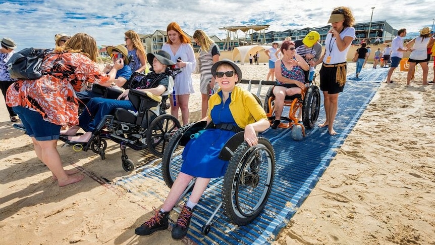 Several wheelchair users prepare to get into the water