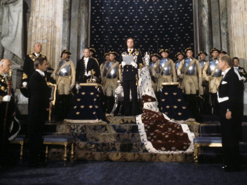 A large group of people standing around a man wearing ceremonial robes