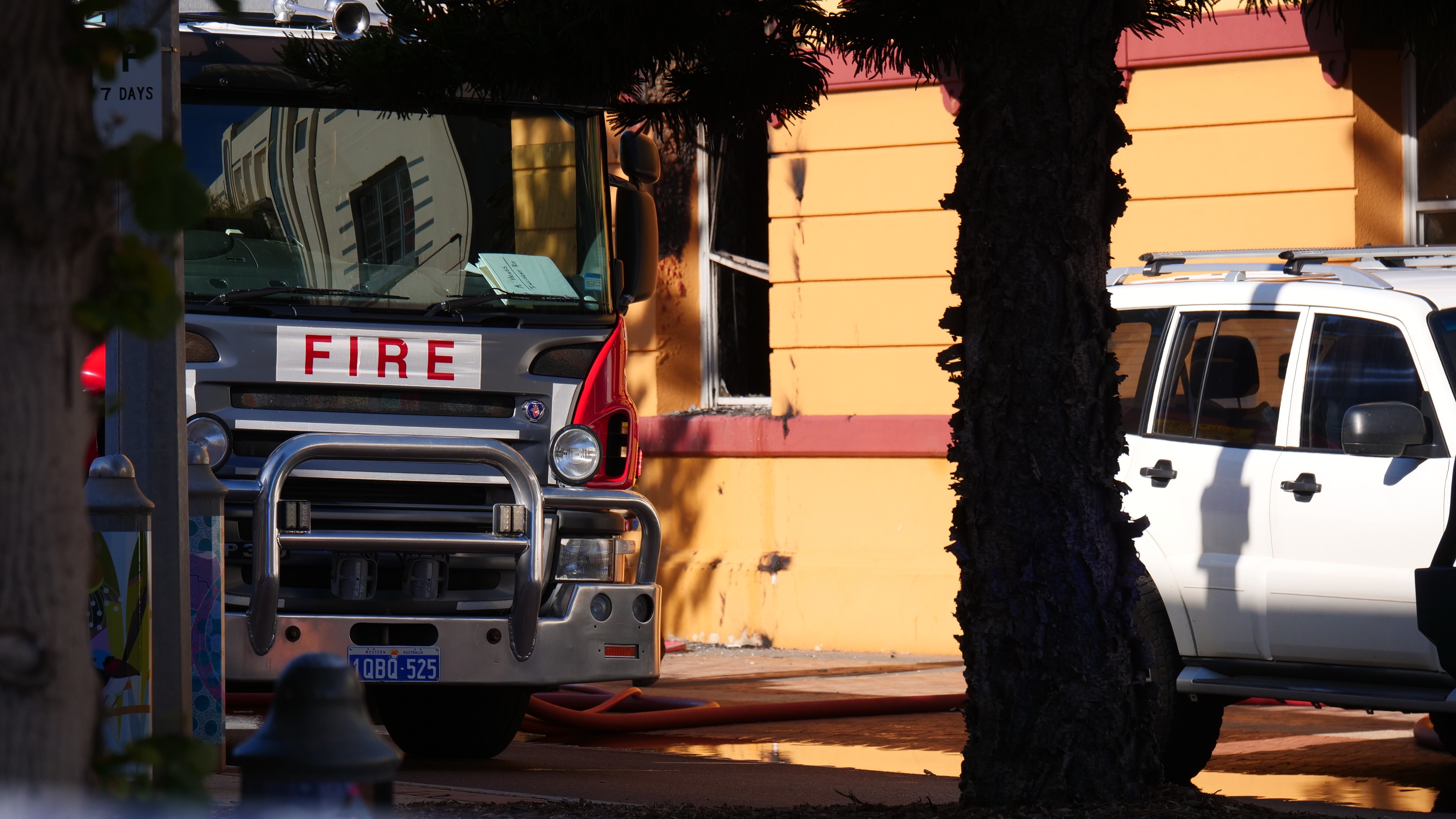 Fire truck in front of a building with a broken window.