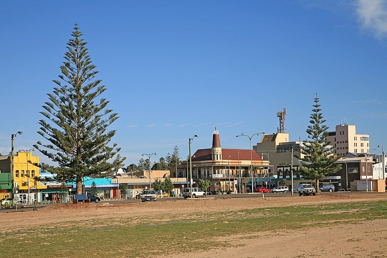 A landscape image of the main street of a country town as viewed from across a park.