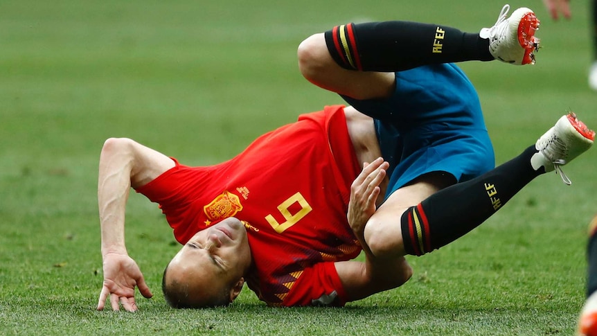 Spain's Andres Iniesta tumbles to the turf against Russia