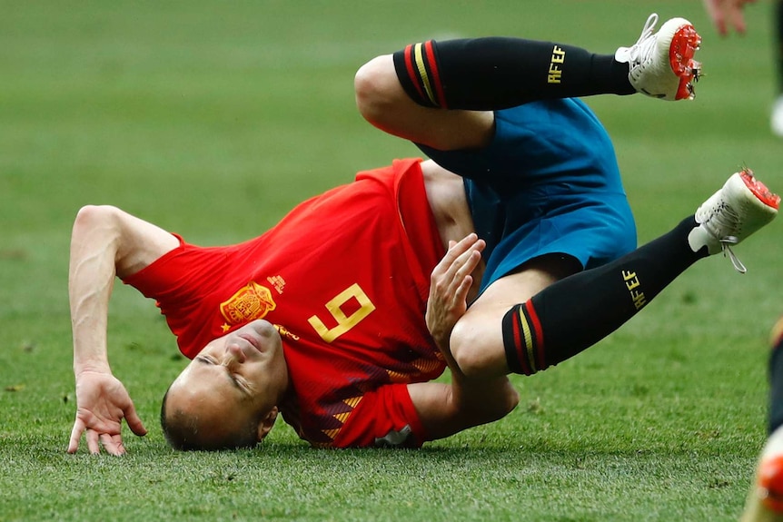 Spain's Andres Iniesta tumbles to the turf against Russia