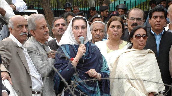 Pakistan Opposition leader Benazir Bhutto speaks to supporters and the media from behind a barricade outside her residence in Islamabad.