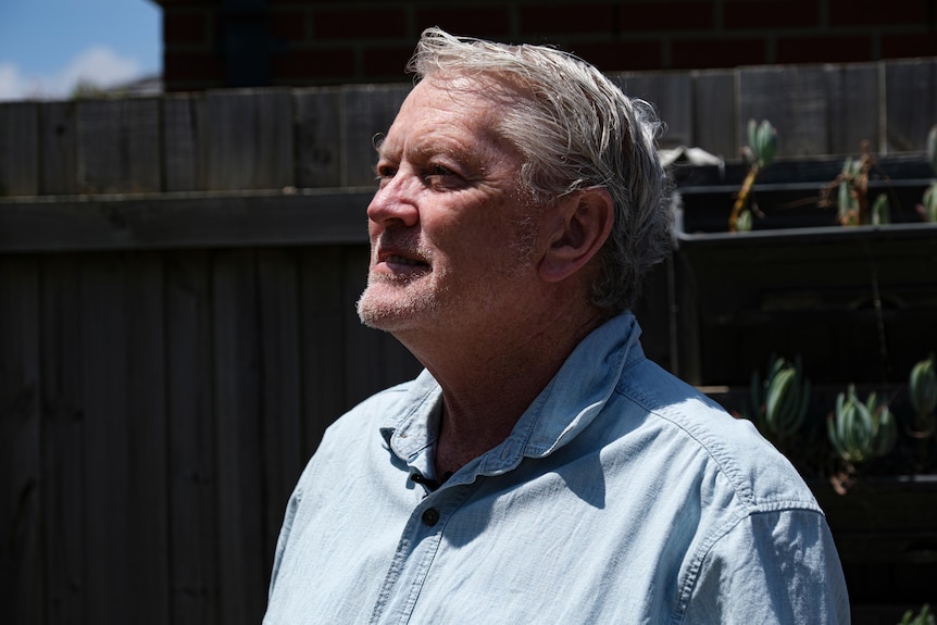 a man with gray hair and a blue shirt.
