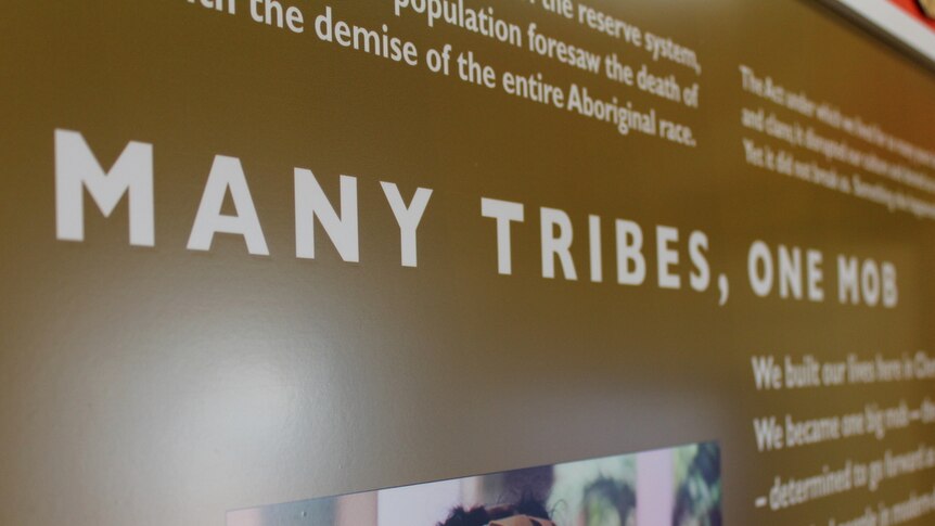 A sign reading 'many tribes, one mob' in the Cherbourg Ration Shed Museum.