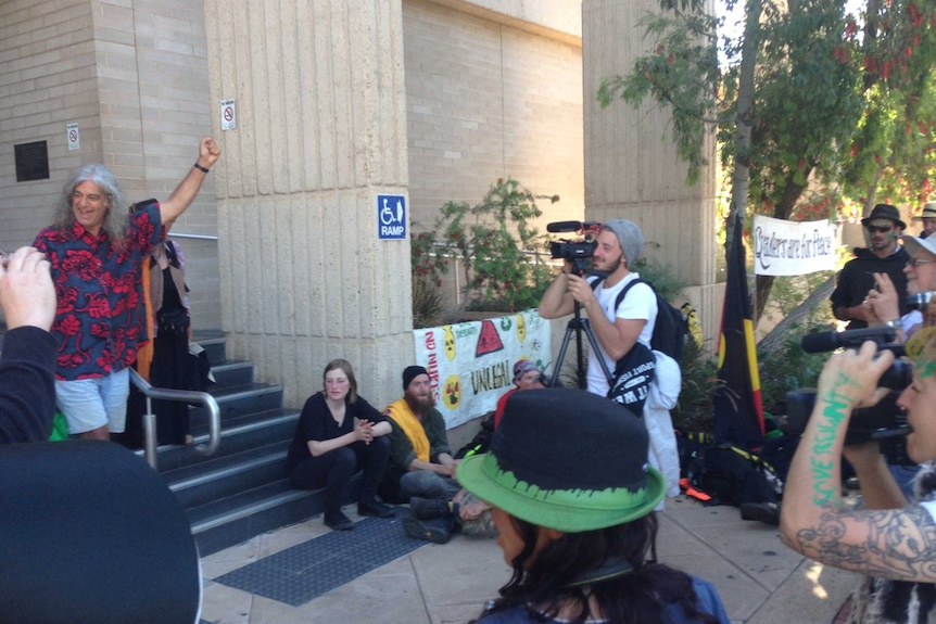 Supporters and protestors against the secret military base at Pine Gap in the Northern Territory celebrate outside court.