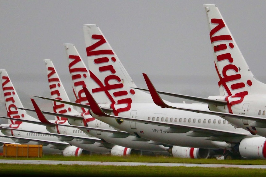 Photo showing Virgin jets parked on a runway.