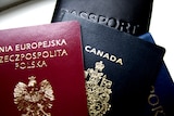A small stack of passports, including from Canada and Poland.