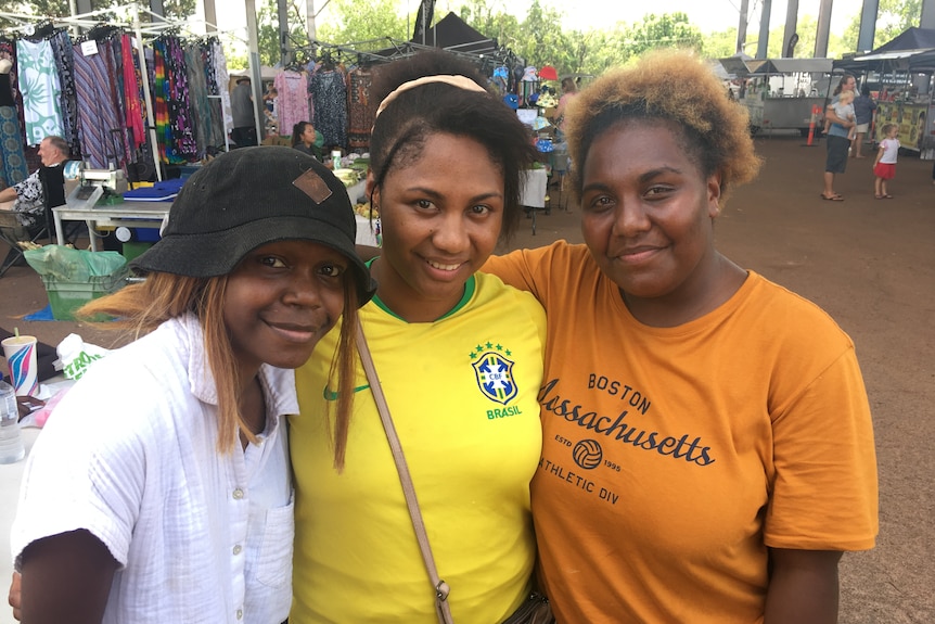 three young women wearing colourful shirts