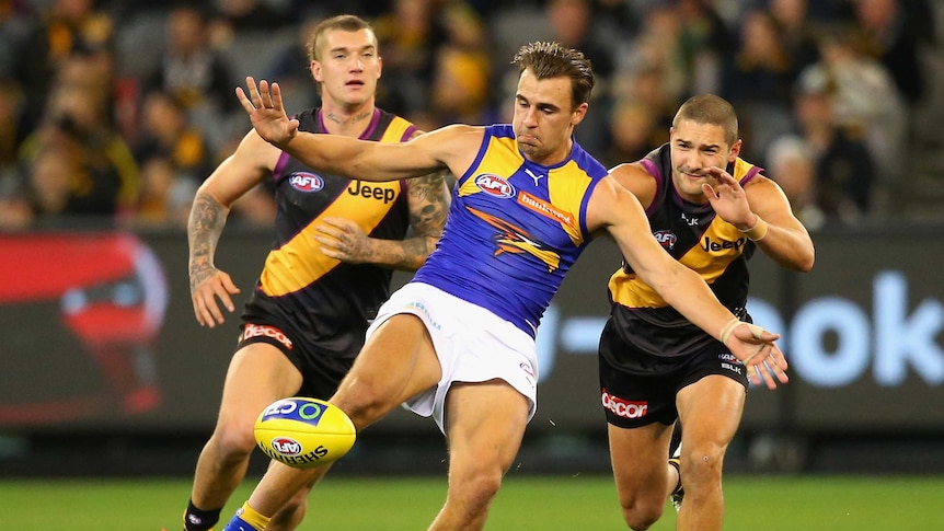 Step ahead ... Dom Sheed kicks whilst being pursued by the Tigers defence
