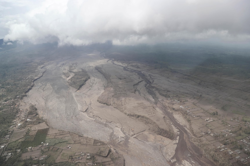 На снимке с воздуха виден след из лавы и пепла, тянущийся вдалеке, как река, после извержения вулкана.