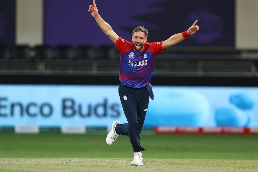 England fast bowler Chris Woakes raises his arms in celebration.