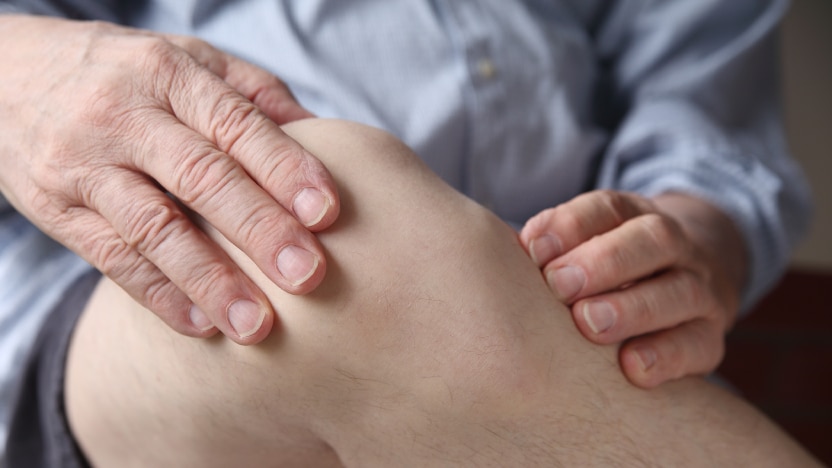 A man holding his painful knee