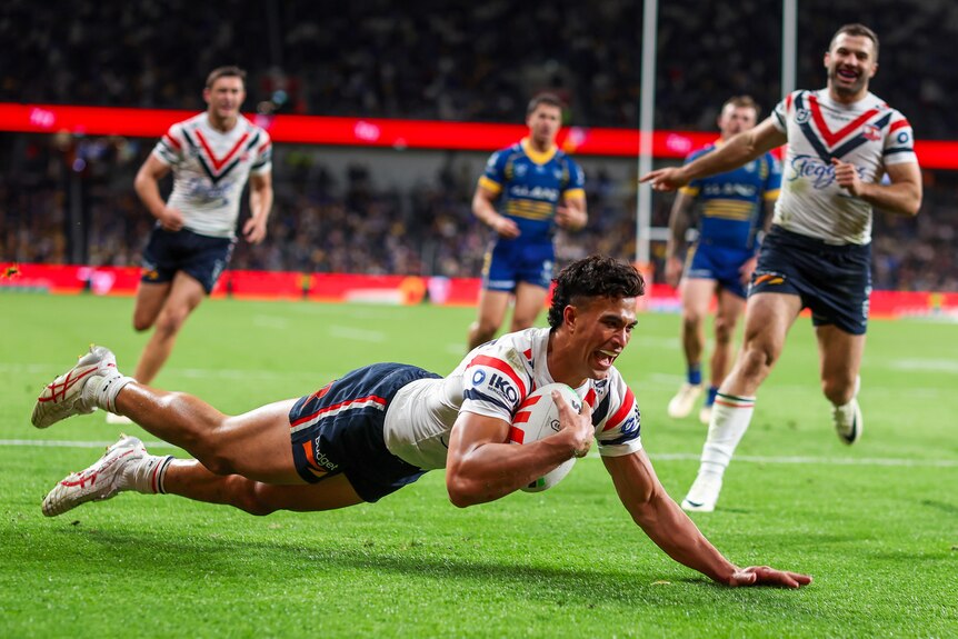 A Sydney Roosters NRL player dives over the line to score a try against the Parramatta Eels.