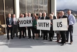 Tasmanian mayors pose with placards urging the minister to "work with us"