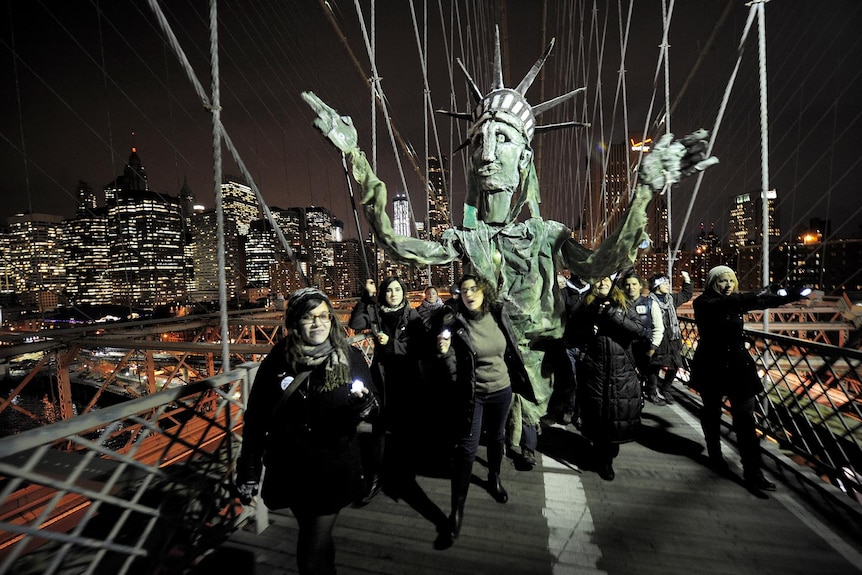 Occupy Wall Street supporters carry a puppet of the Statue of Liberty across the Brooklyn Bridge.