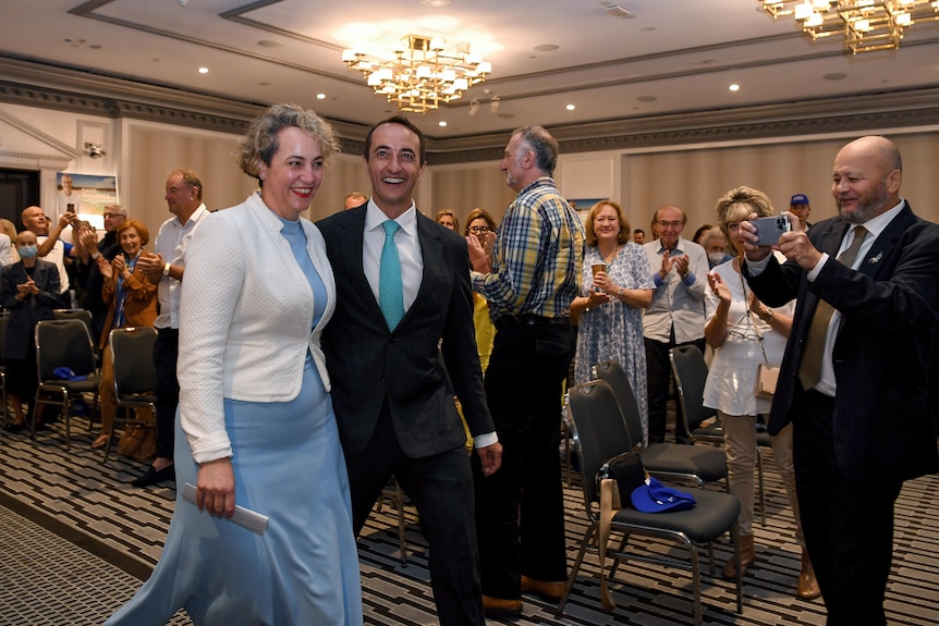 a man and a woman hugging and walking into a room