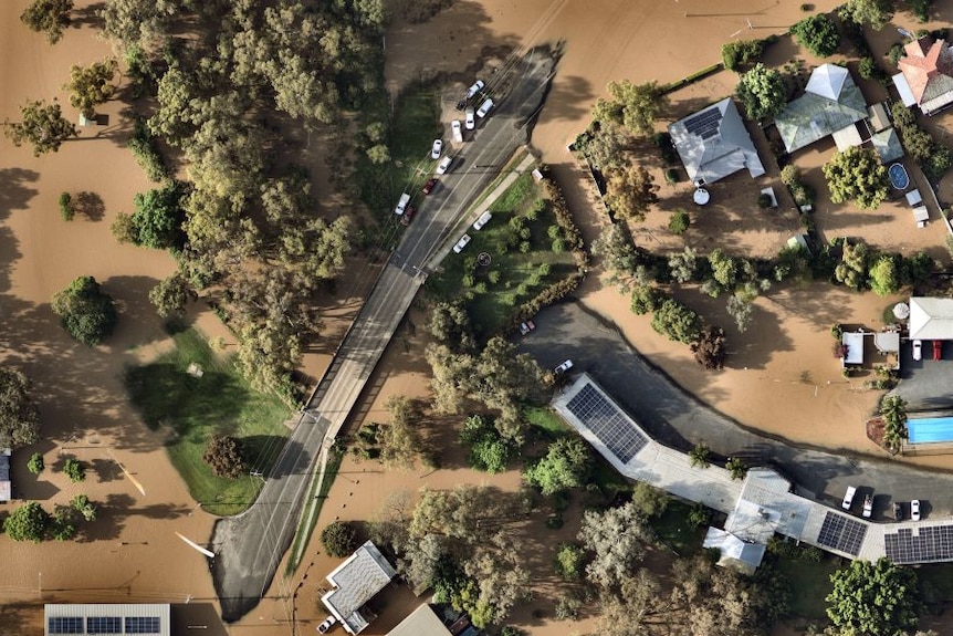 Aerial view of cars on a bridge surrounded by flood water