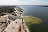 A view from above of a lake with exposed land on the bank. 