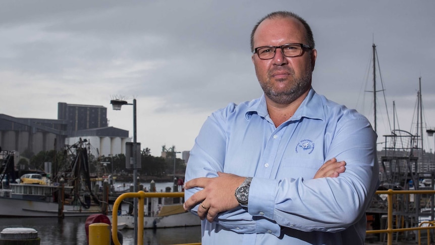 Robert Gauta stands near Newcastle Harbour.