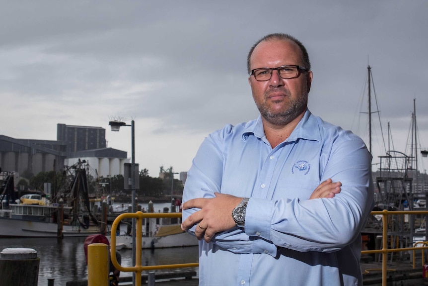 Robert Gauta stands near Newcastle Harbour.