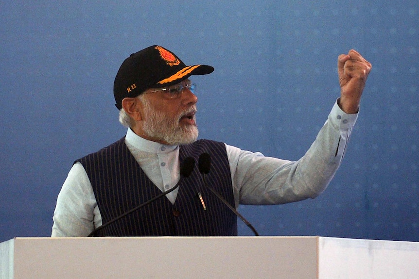 Le Premier ministre indien Narendra Modi fait des gestes pendant qu'il parle lors de la mise en service d'un porte-avions
