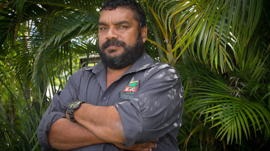 a man staring at the camera with arms crossed