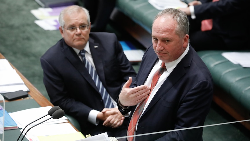 Scott Morrison sitting in the House of Representatives looking up at Barnaby Joyce who is speaking but gesturing to himself