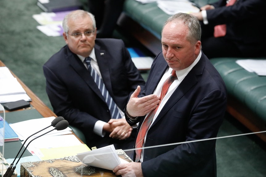 Scott Morrison sitting in the House of Representatives looking up at Barnaby Joyce who is speaking but gesturing to himself