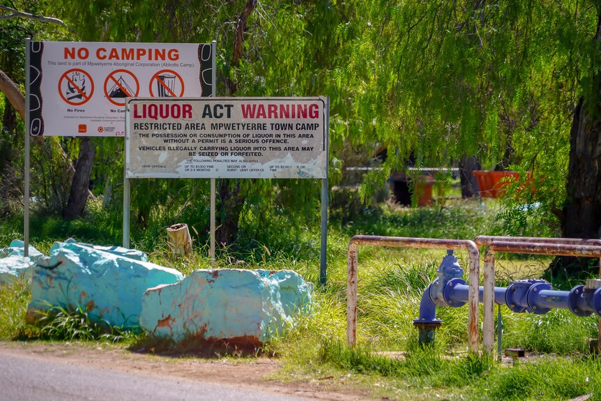 signs warning against camping and drinking alcohol at a town camp