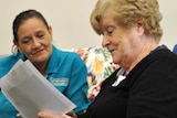 Pam Gorman looks at a picture while sitting next to a respite carer.