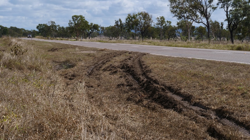 Muddy tyre tracks coming off a highway.