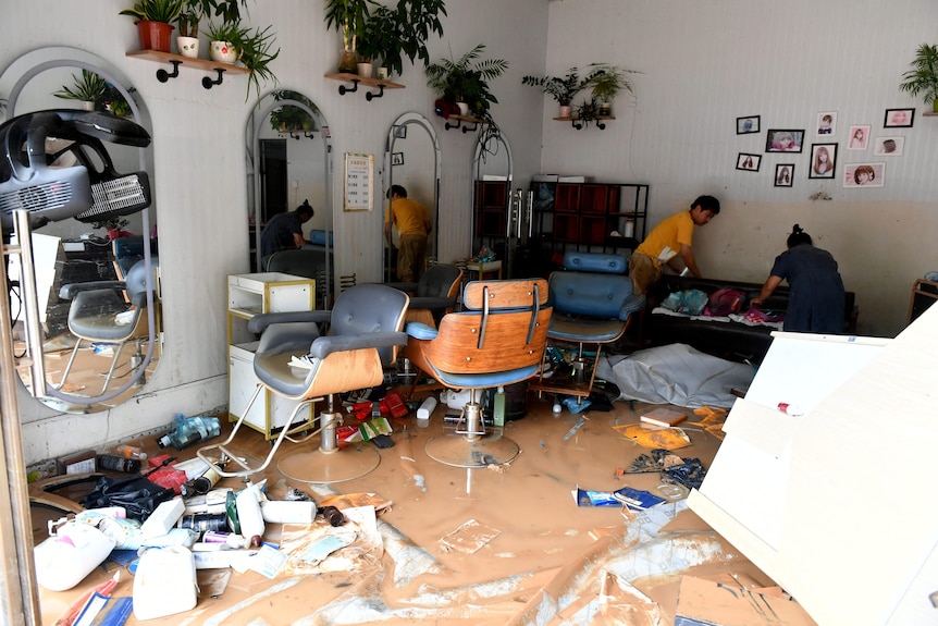 People clean a flooded salon.