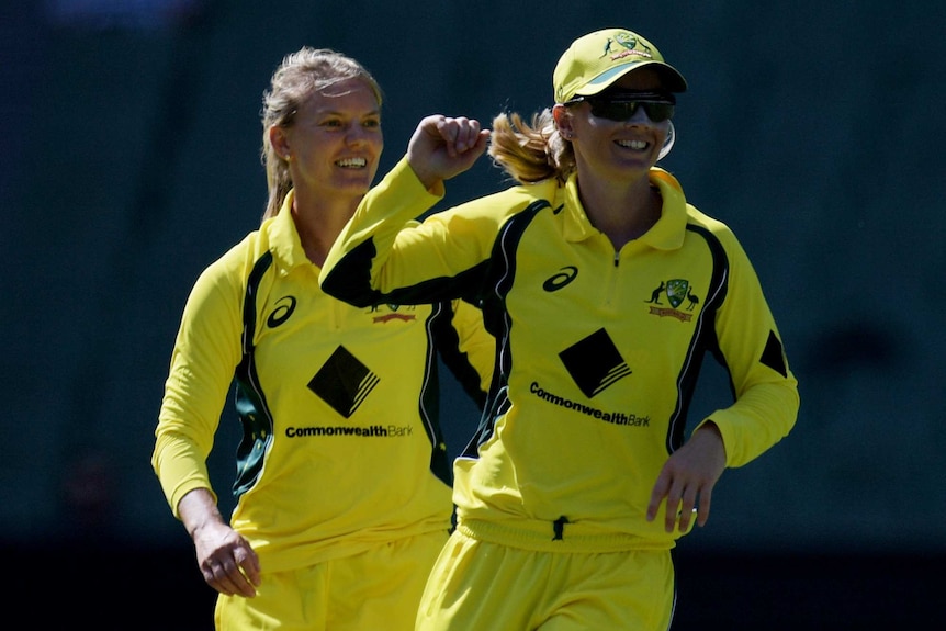 Kristen Beams (L) celebrates with Australia captain Meg Lanning after bowling Erin Bermingham.