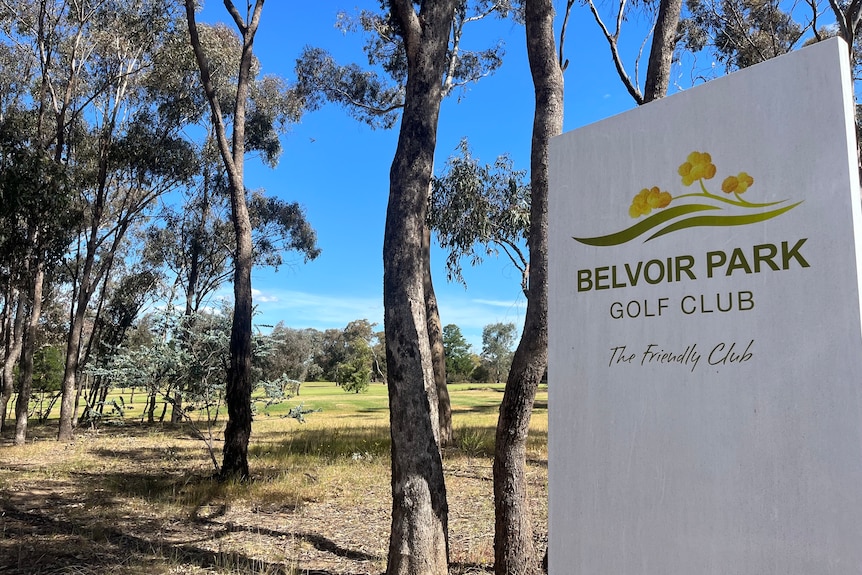 A sign saying Belvoir Park Golf Club in a bushland area.