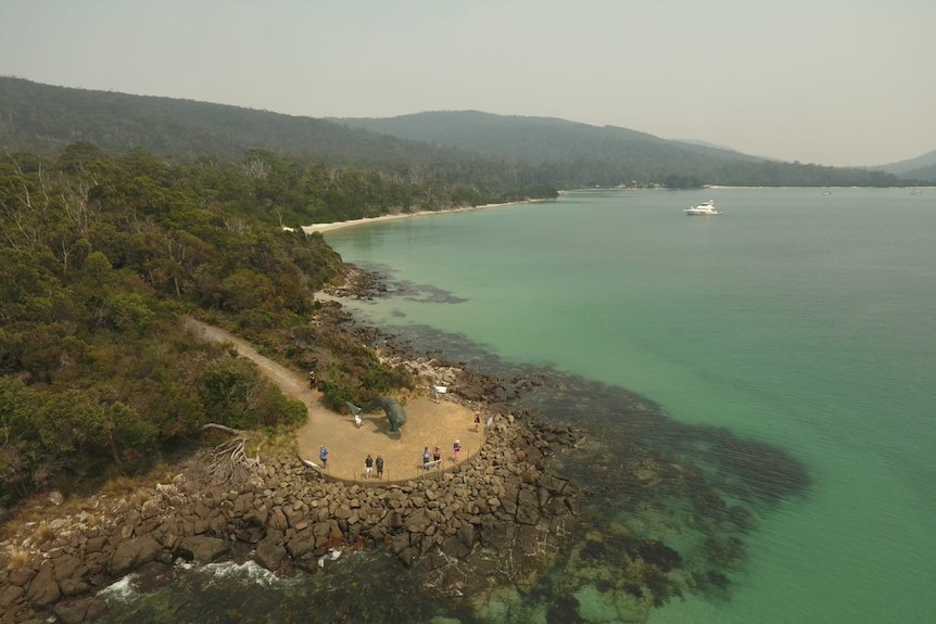 Picture of clear water and bush and people at a look out