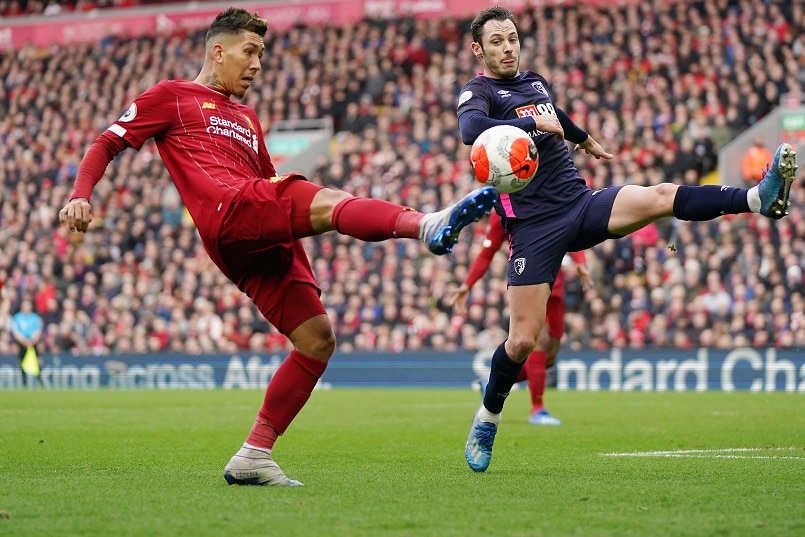 Soccer players kicking a ball.