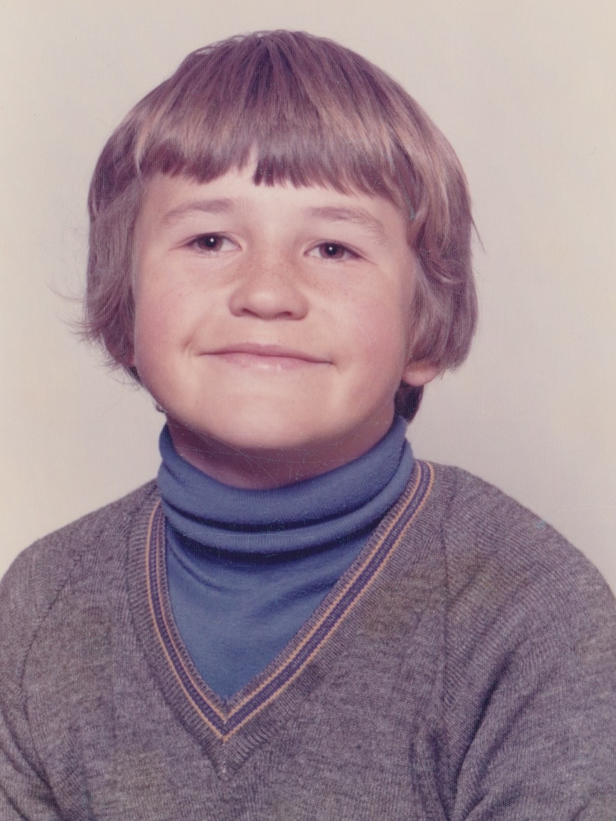 A young boy looks at the camera.