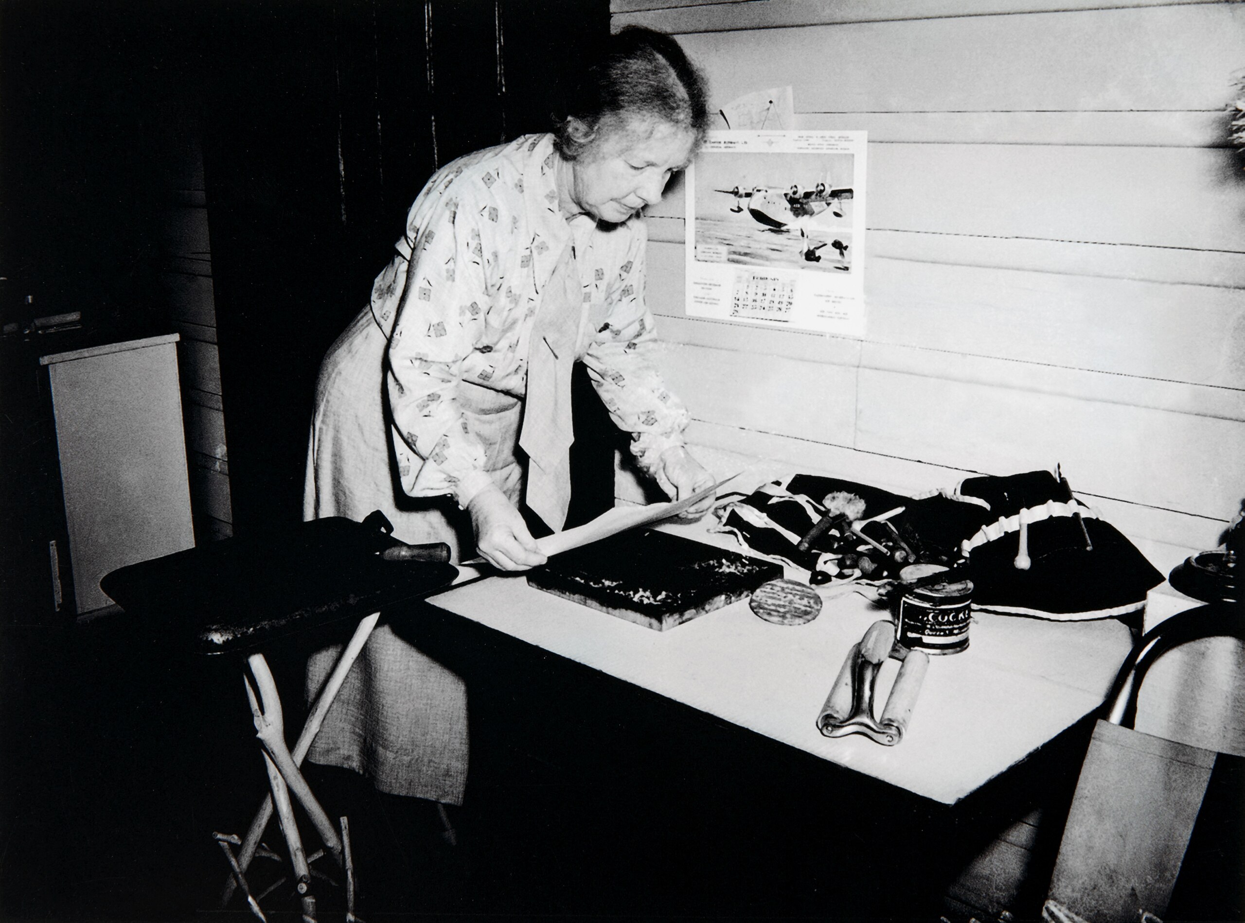 A black and white photograph of the artist Margaret Preston in the 1930s doing a woodblock print