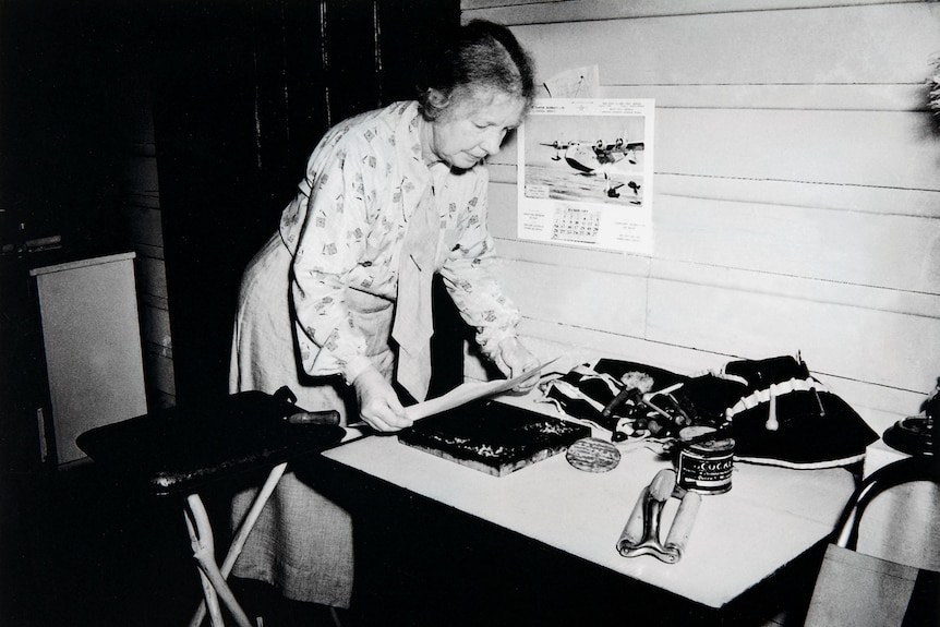 A black and white photograph of the artist Margaret Preston in the 1930s doing a woodblock print