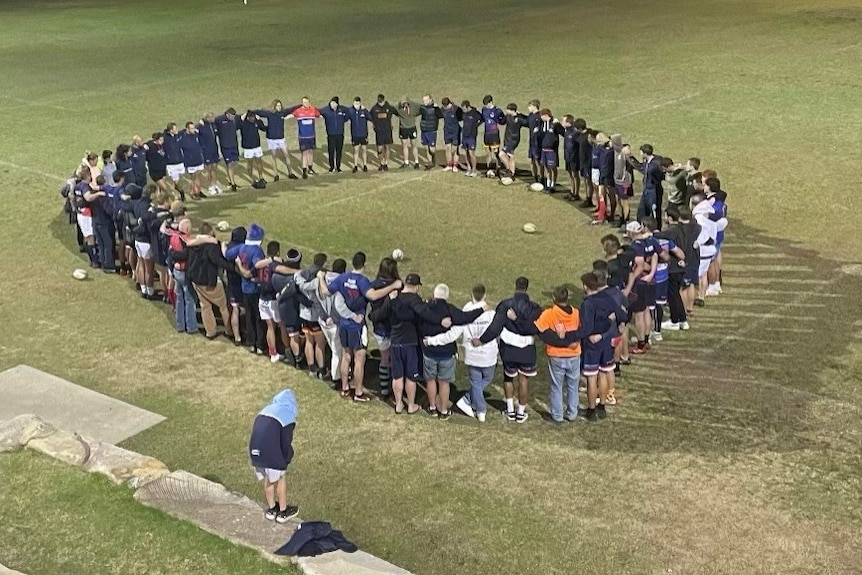 A circle of people on a football field
