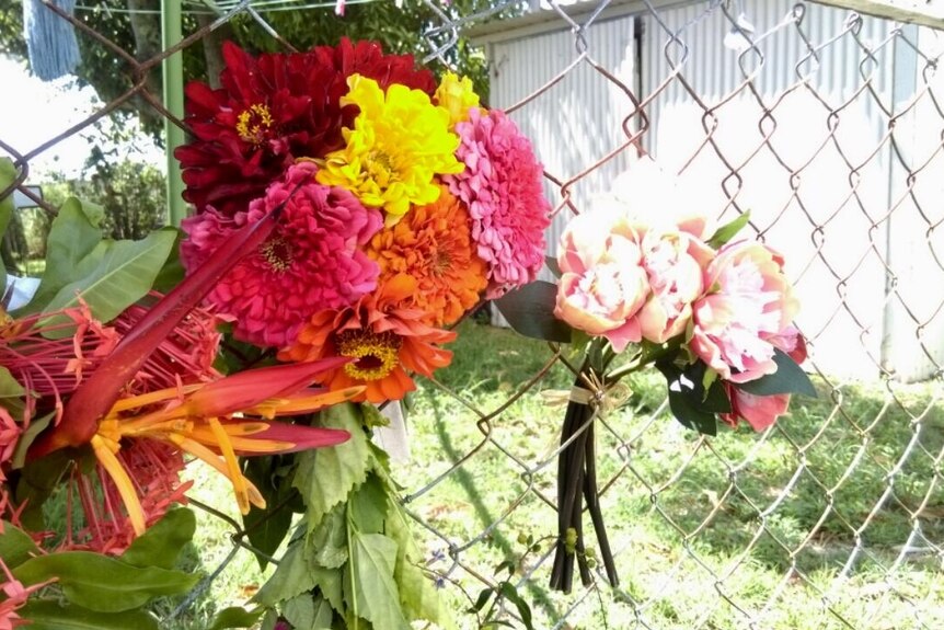 Flower tributes left on the wire fence of a house at Yeppoon.