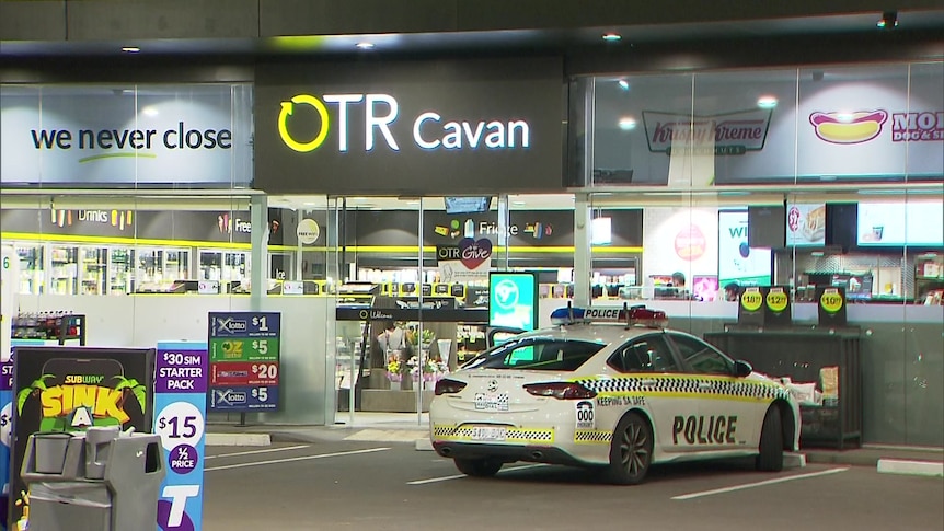 A police car outside a petrol station shop