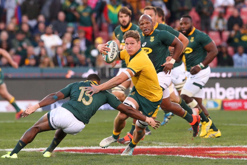 Michael Hooper looks to sidestep a Springboks tackle as he holds the ball