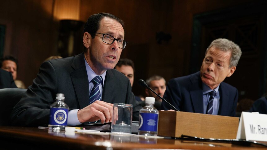 AT&T CEO Randall Stephenson sits next to and Time Warner's Jeffrey Bewkes