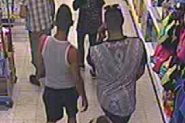 Three men are seen from the back, talking through the store on CCTV footage.