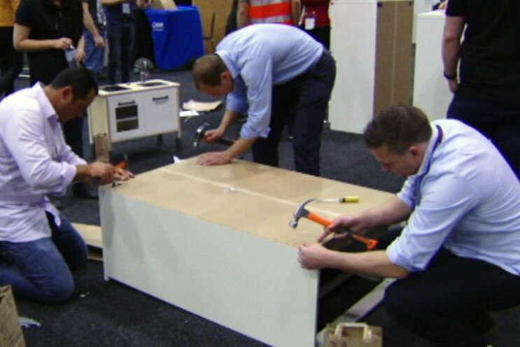 Office workers build furniture for refuges