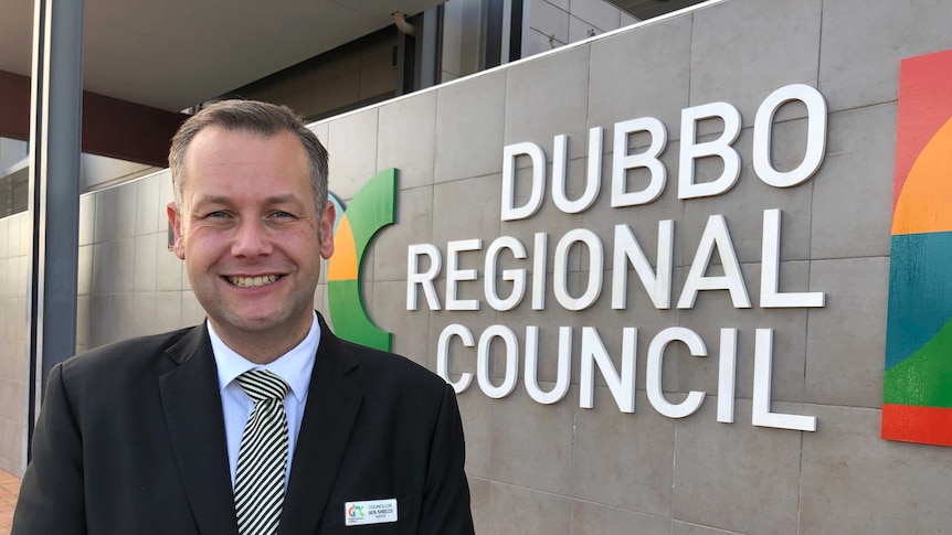 Ben Shields, Dubbo Mayor, standing in front of city council sign